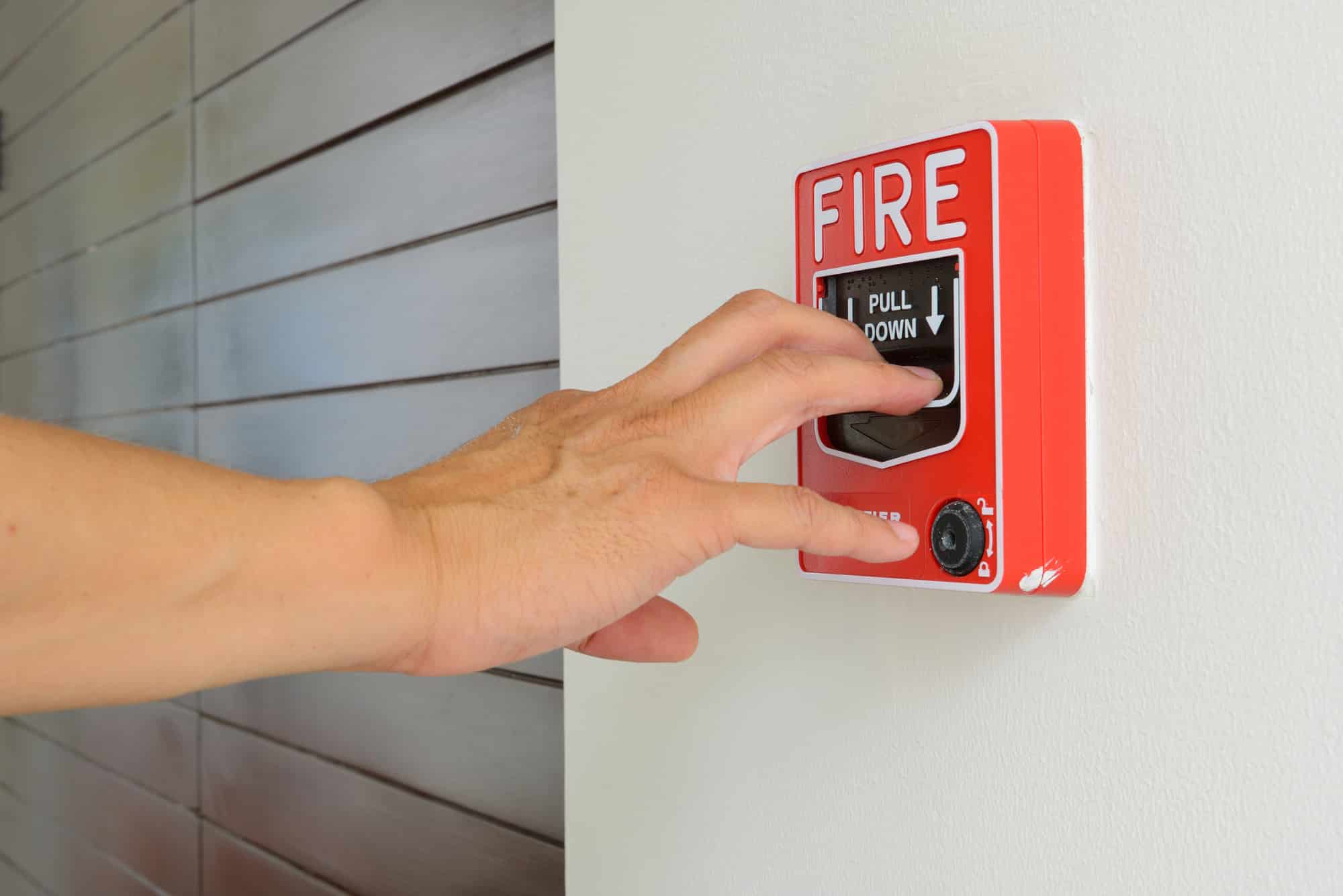 The Hand of a man is pulling fire alarm